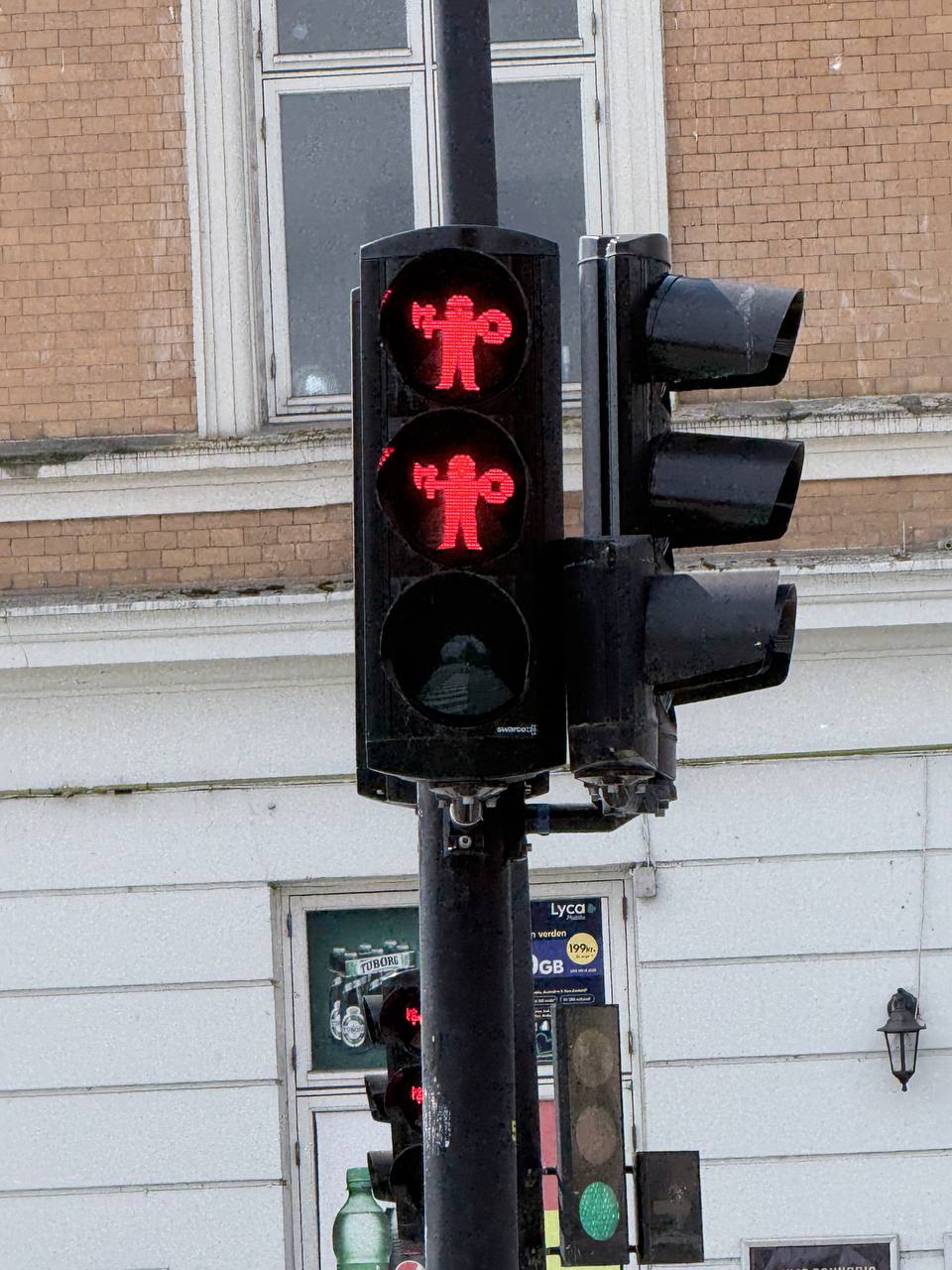 Red pedestrian traffic light with figures holding hands, Aarhus street