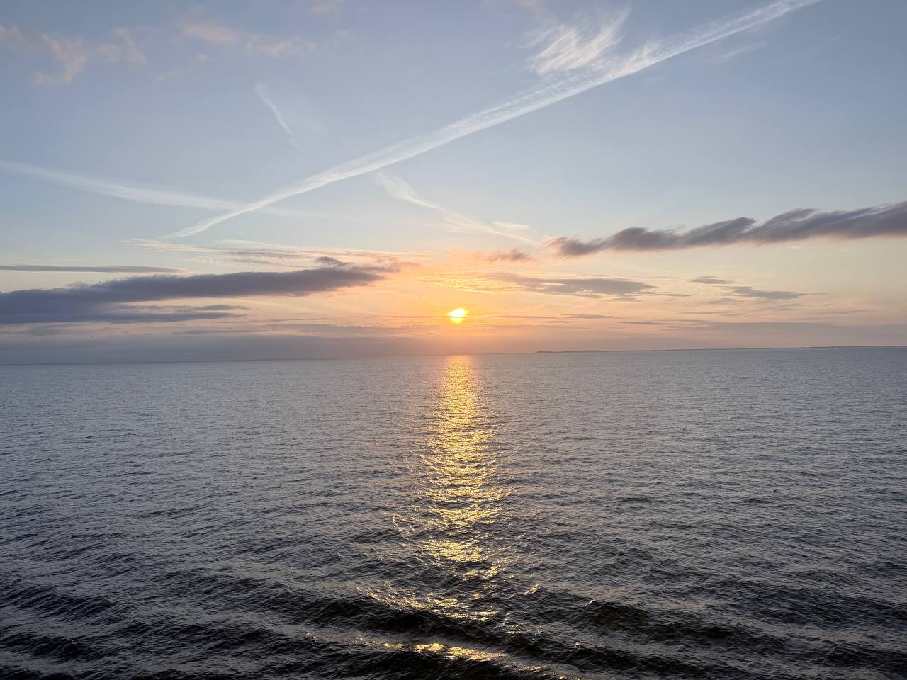 Sunset over Aarhus with harbour waters, buildings silhouetted against orange sky