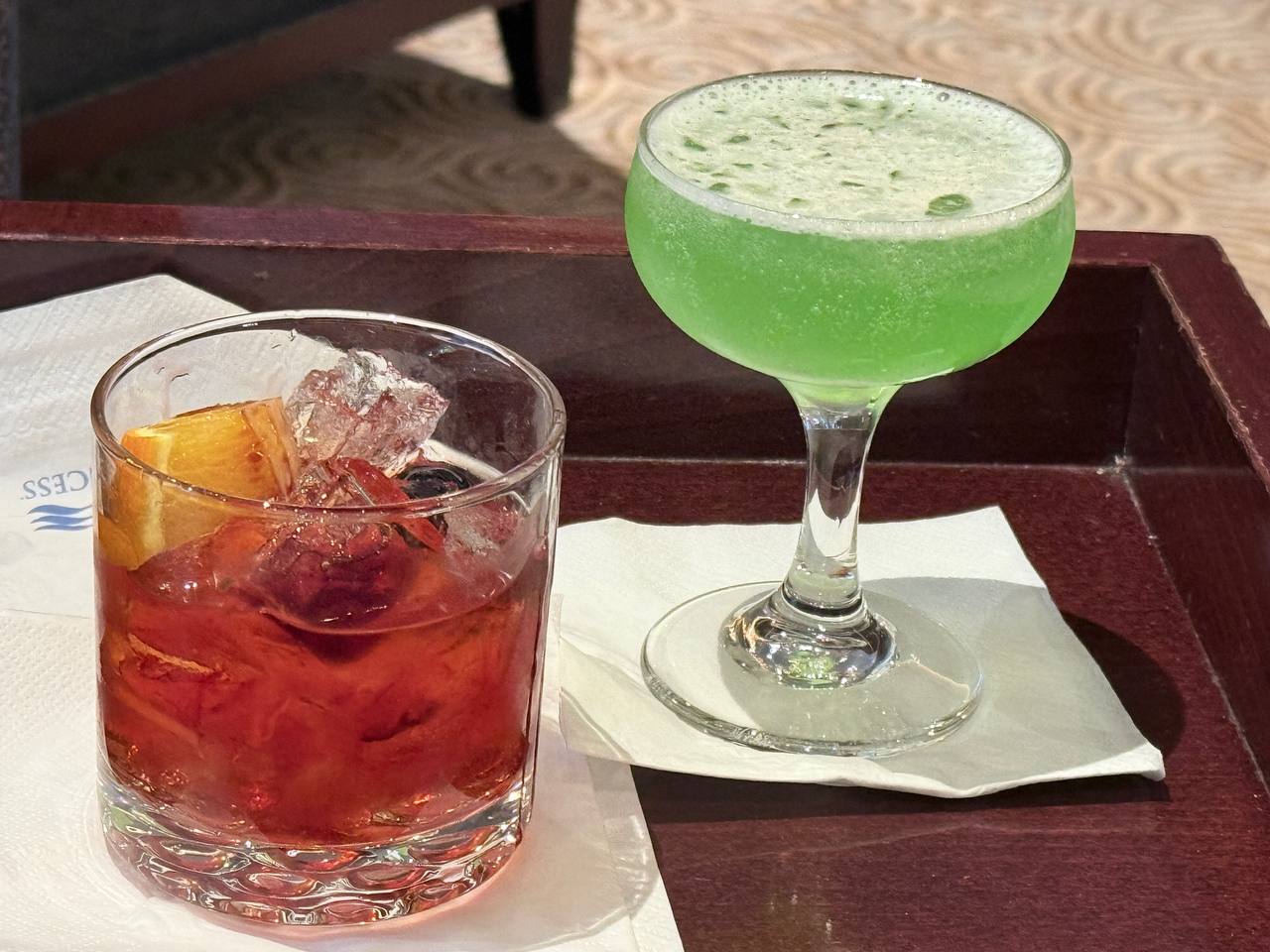 Two cocktails on a wooden tray