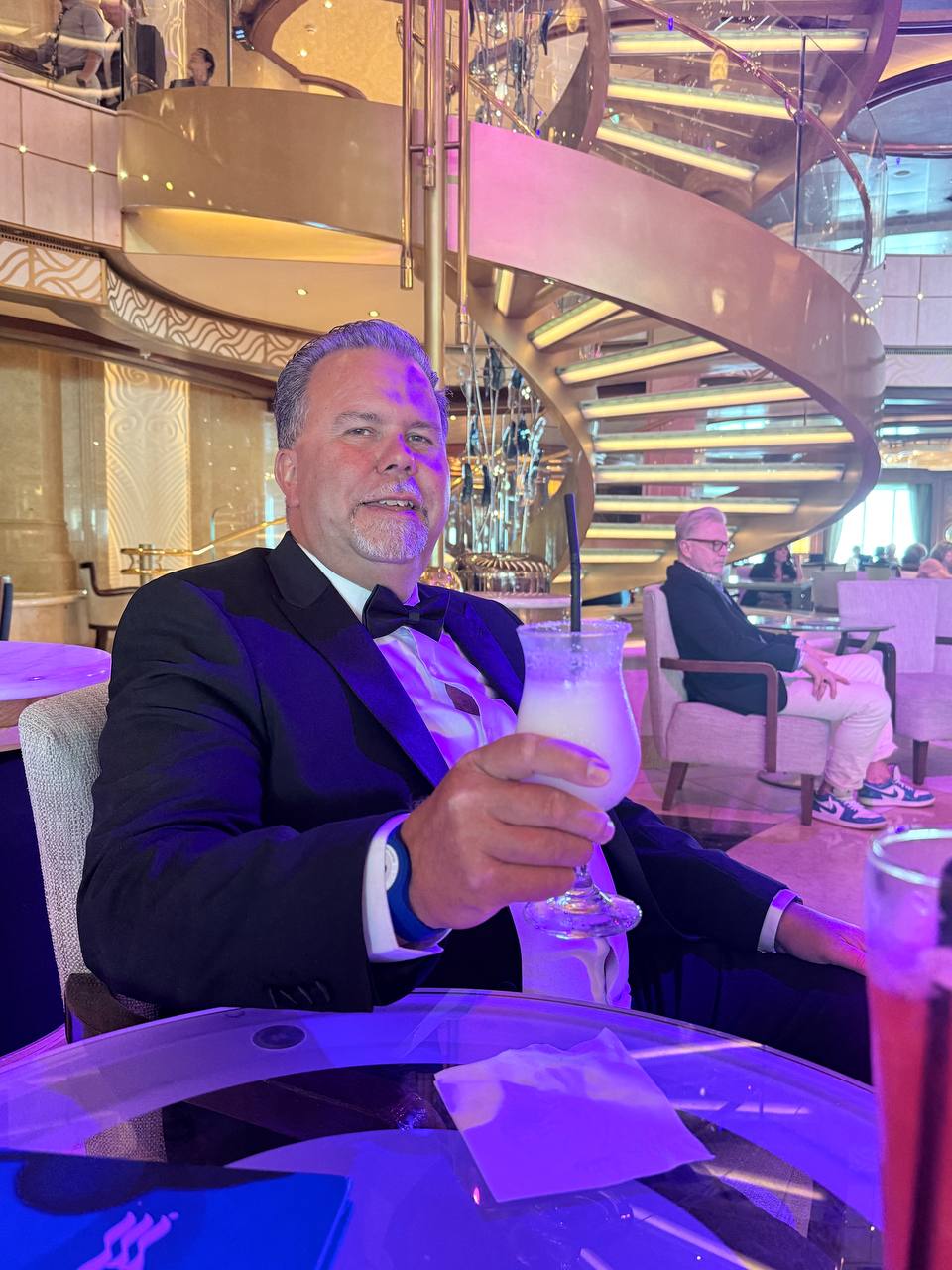 Man in tuxedo holding a cocktail in the lounge