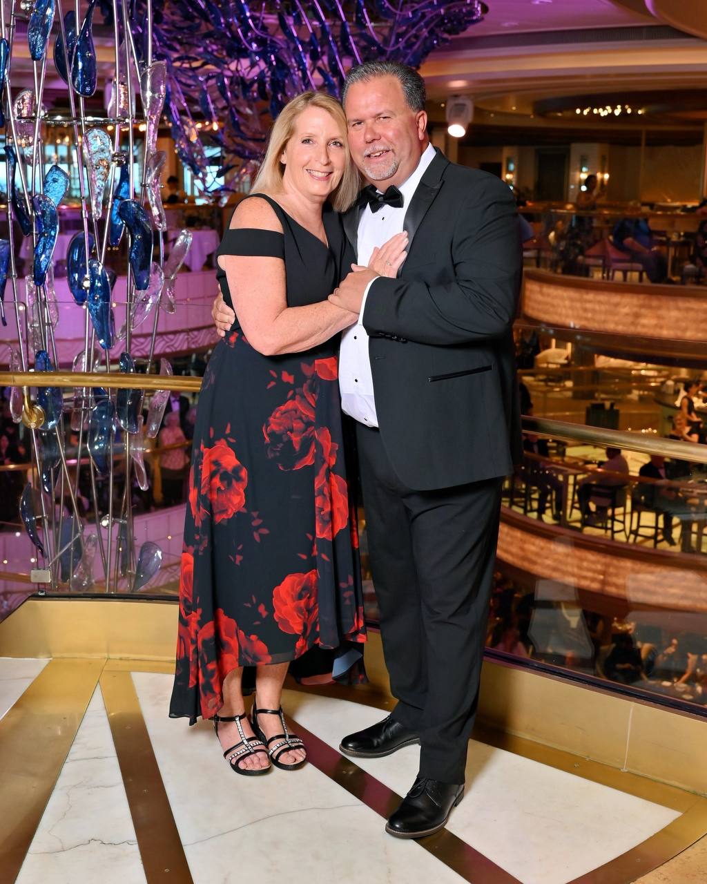 Formal portrait in cruise ship atrium with blue and purple glass sculpture