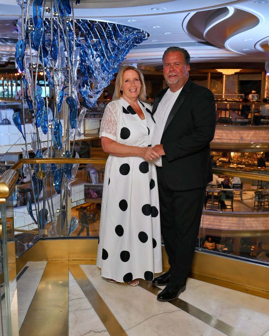 Formal portrait in cruise ship atrium with blue glass sculpture