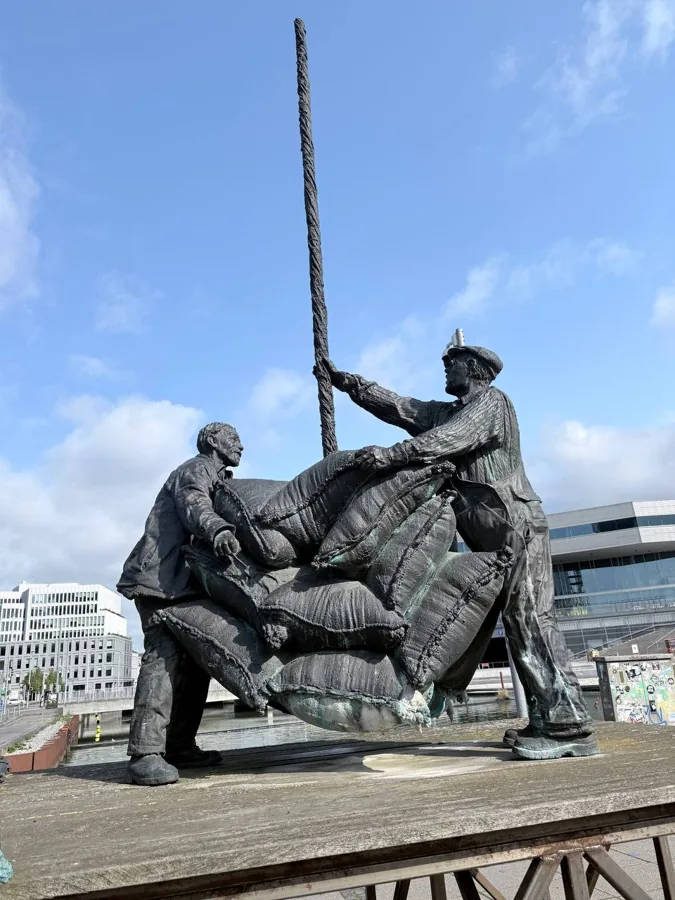 Bronze sculpture of two dock workers lifting heavy sacks on Aarhus waterfront