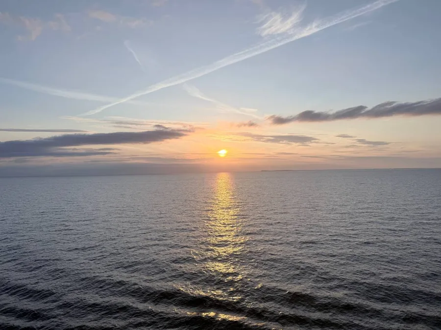 Sunset over Aarhus with harbour waters, buildings silhouetted against orange sky