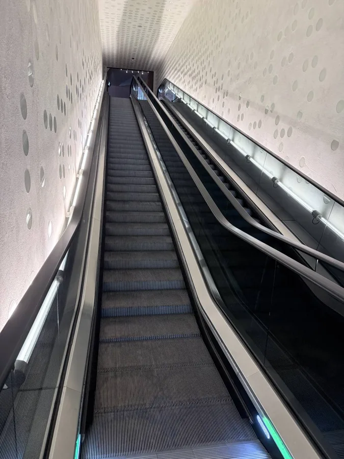 Symmetrical escalator system viewed from below with green LED strips